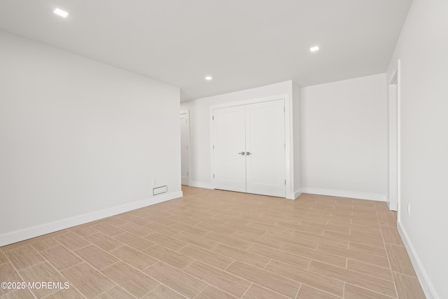 unfurnished room featuring recessed lighting, baseboards, and wood tiled floor