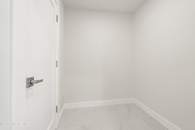 interior space featuring baseboards and marble finish floor