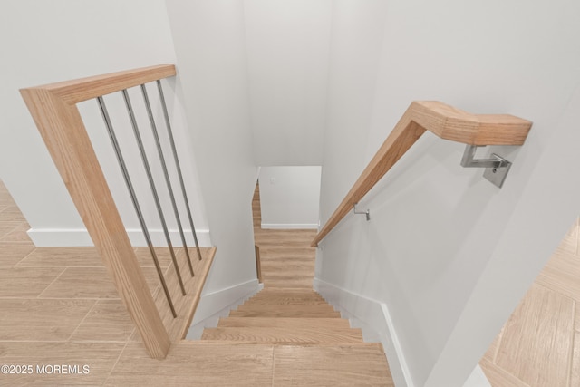 staircase with wood finished floors and baseboards