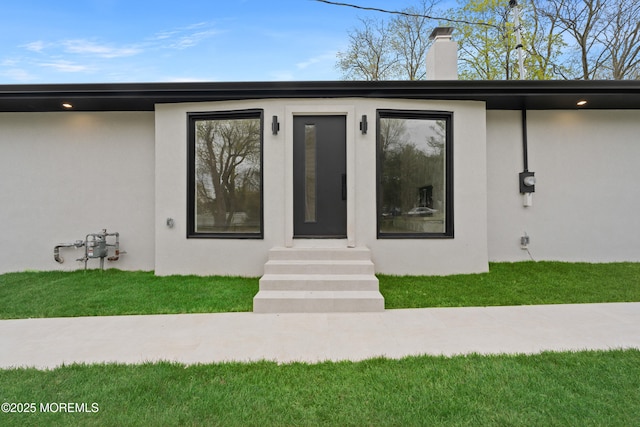 doorway to property with stucco siding and a chimney