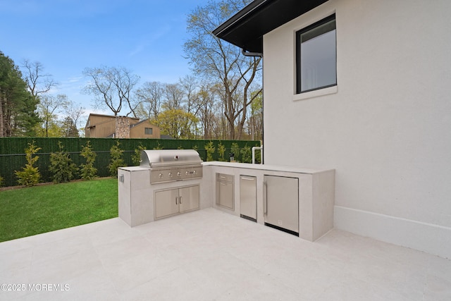 view of patio with area for grilling, a fenced backyard, and a grill