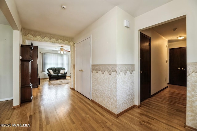 hallway featuring baseboards and wood finished floors