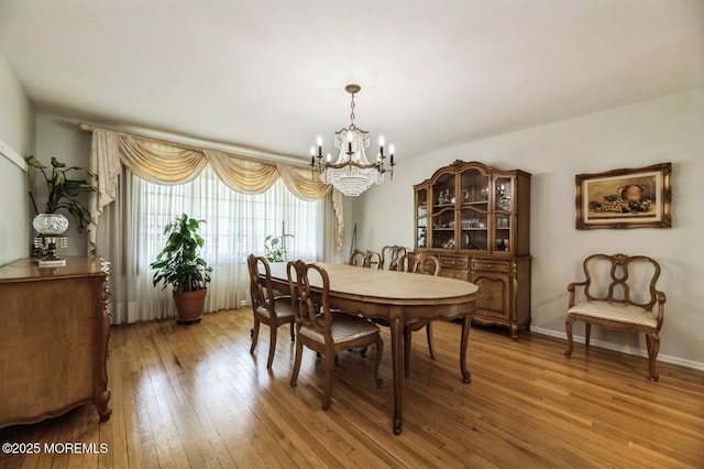 dining room with a chandelier and light wood finished floors