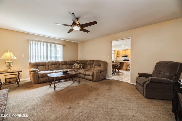 living area with carpet floors, a ceiling fan, and baseboards