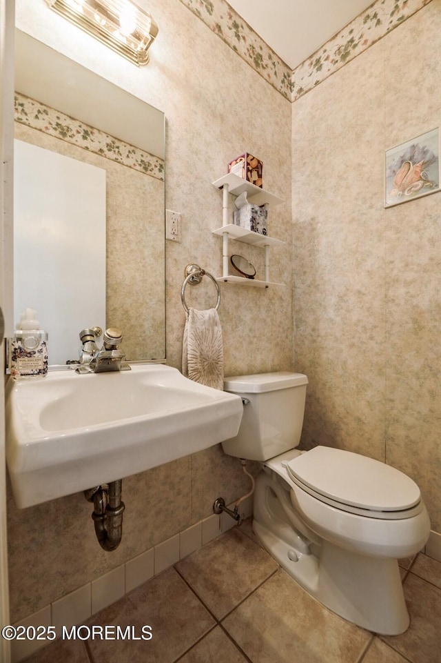bathroom featuring tile patterned flooring, a sink, and toilet