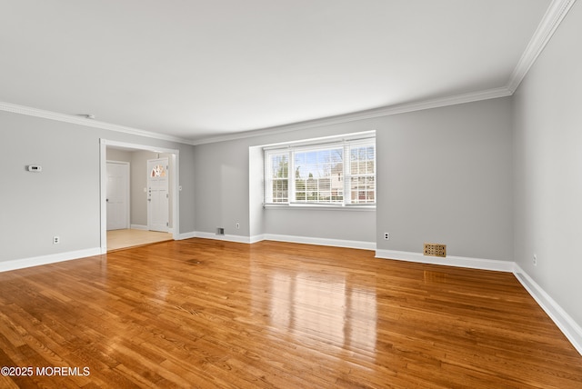 unfurnished room featuring baseboards, light wood-style floors, and ornamental molding