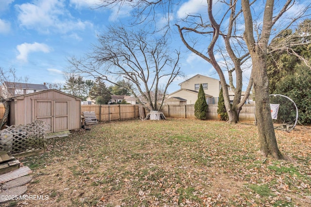 view of yard featuring an outbuilding, a fenced backyard, and a shed