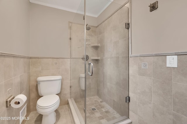 full bath featuring toilet, tile walls, and a shower stall