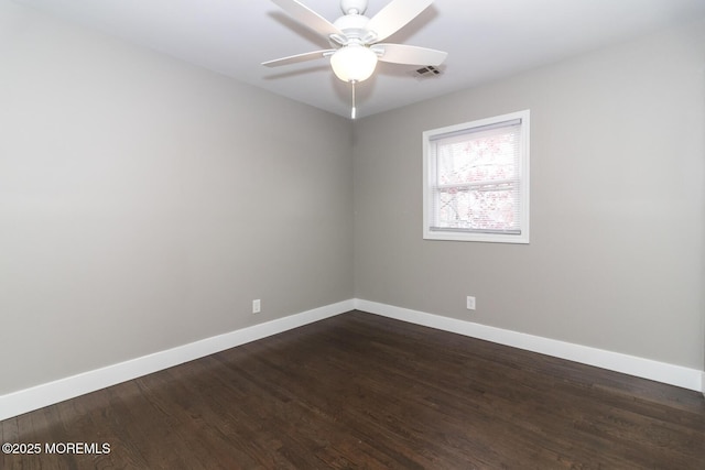 empty room featuring visible vents, baseboards, a ceiling fan, and dark wood-style flooring