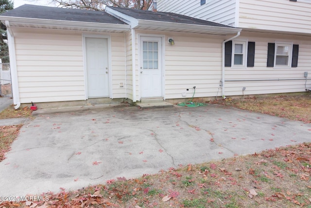 exterior space with a patio and roof with shingles