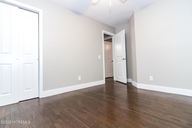 unfurnished bedroom featuring a ceiling fan, wood finished floors, baseboards, and a closet