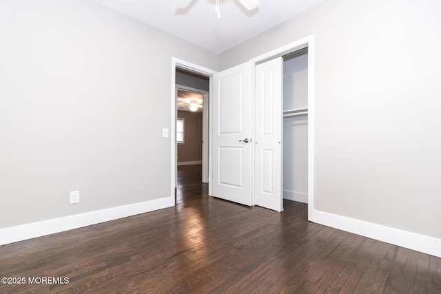 unfurnished bedroom featuring dark wood-style floors, a closet, and baseboards