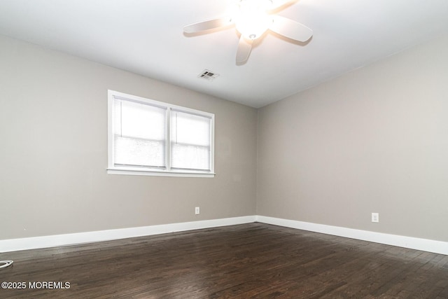 unfurnished room with ceiling fan, visible vents, baseboards, and dark wood-style floors