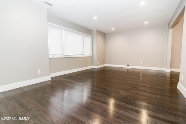 unfurnished room with recessed lighting, visible vents, baseboards, and dark wood-type flooring