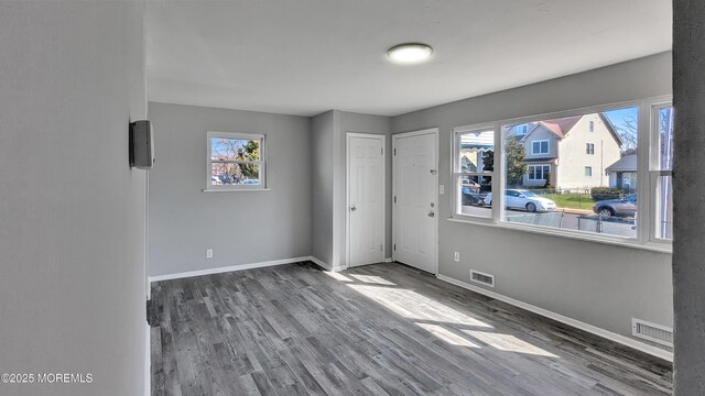 unfurnished bedroom with visible vents, baseboards, and wood finished floors