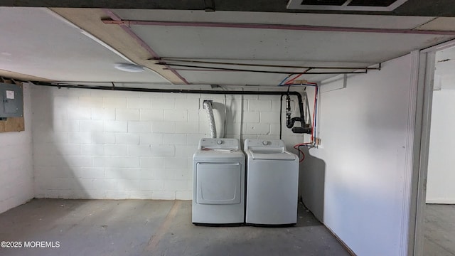 laundry area featuring electric panel, laundry area, independent washer and dryer, and concrete block wall