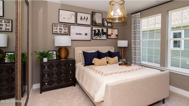 bedroom with baseboards and light carpet