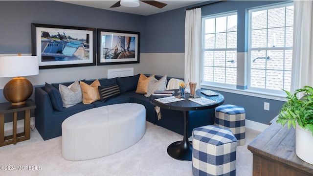 living area featuring plenty of natural light, baseboards, and ceiling fan