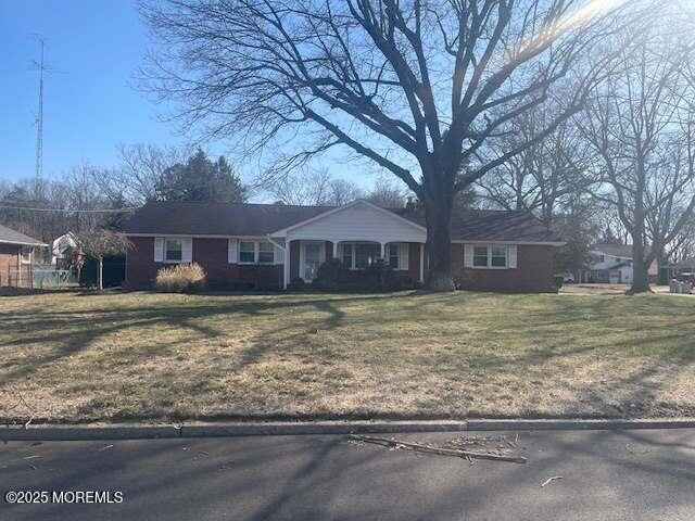 single story home with covered porch and a front lawn