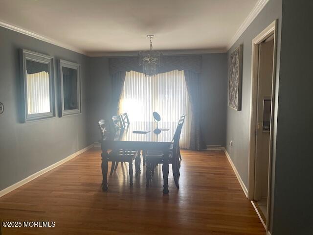 dining area with a notable chandelier, baseboards, and wood finished floors