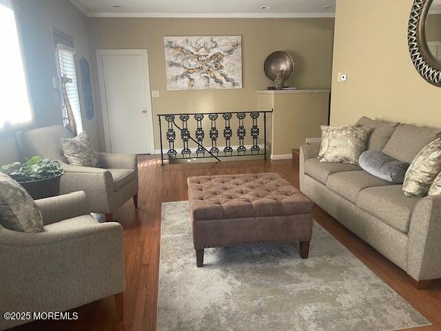 living area featuring ornamental molding and wood finished floors