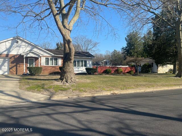 single story home featuring a garage and a front yard