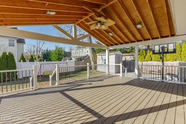 deck featuring a storage shed, a fenced backyard, and an outdoor structure