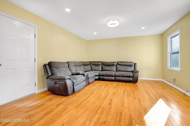 living room with recessed lighting, visible vents, baseboards, and wood finished floors