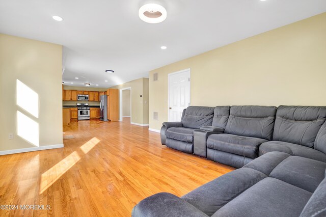 living area with recessed lighting, light wood-type flooring, baseboards, and visible vents