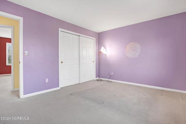 unfurnished bedroom with a closet, baseboards, and carpet floors