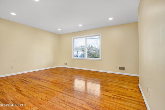 spare room featuring light wood finished floors, visible vents, recessed lighting, and baseboards