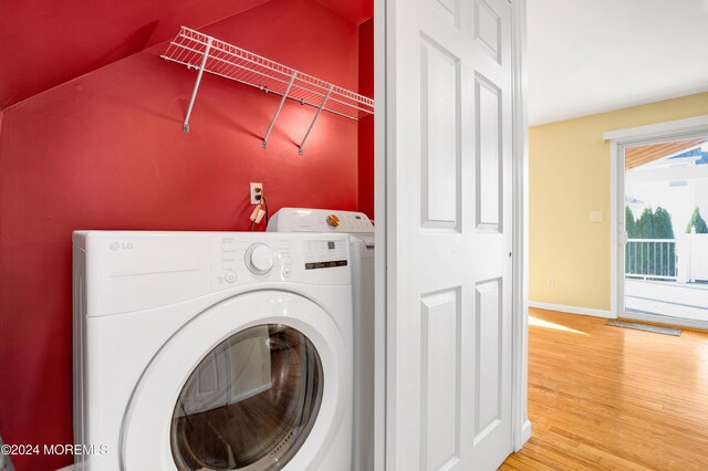 laundry room with baseboards, washer / dryer, wood finished floors, and laundry area