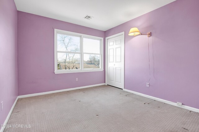 interior space with baseboards, carpet floors, and visible vents