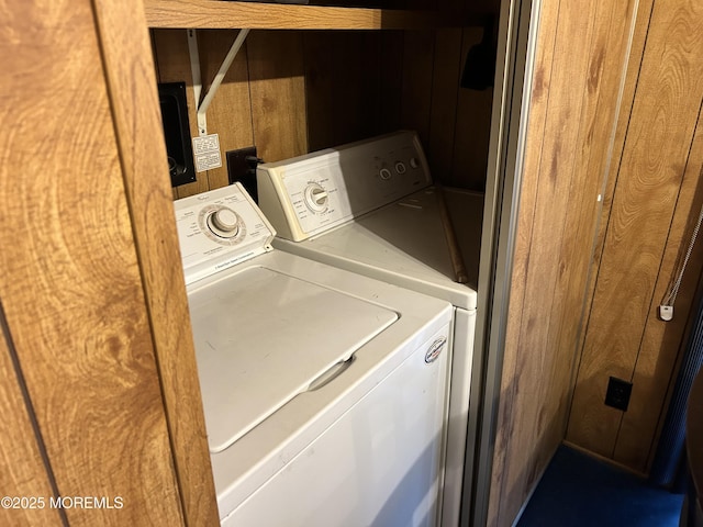 laundry room featuring laundry area, independent washer and dryer, and wood walls