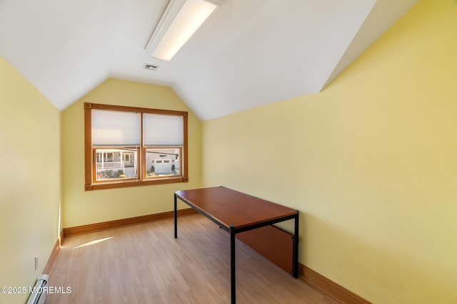 unfurnished office featuring vaulted ceiling, light wood-style flooring, baseboards, and visible vents