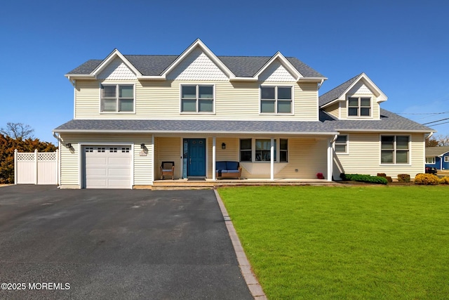 view of front of property featuring fence, driveway, a porch, an attached garage, and a front lawn