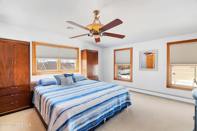 bedroom featuring visible vents, light carpet, multiple windows, and a baseboard heating unit