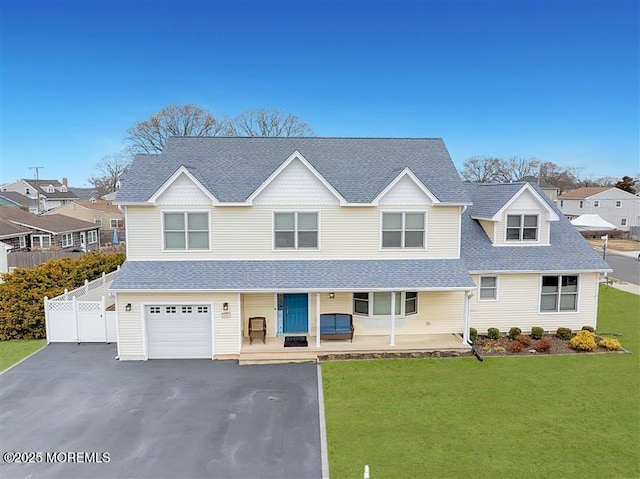 view of front of house featuring fence, a shingled roof, a front lawn, driveway, and a porch