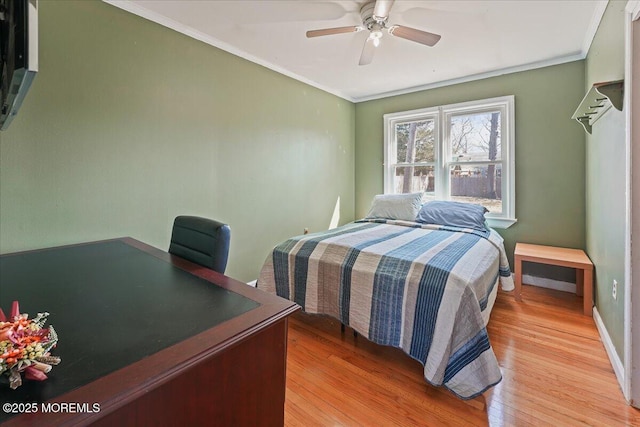 bedroom featuring ceiling fan, light wood-type flooring, baseboards, and ornamental molding