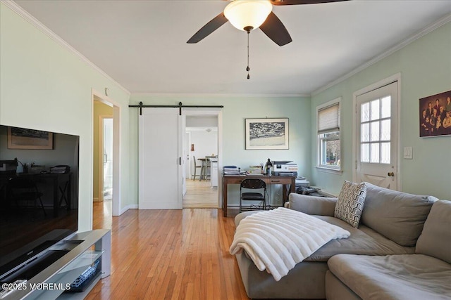 living area featuring light wood-style flooring, crown molding, a barn door, and ceiling fan