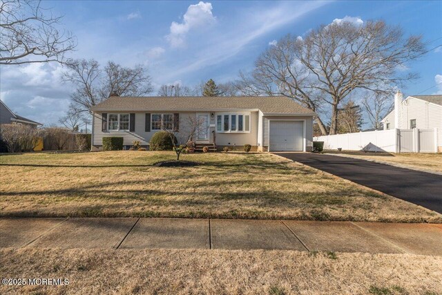 single story home with a front lawn, fence, aphalt driveway, entry steps, and an attached garage