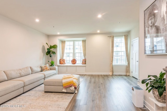 living room with recessed lighting, a healthy amount of sunlight, and wood finished floors