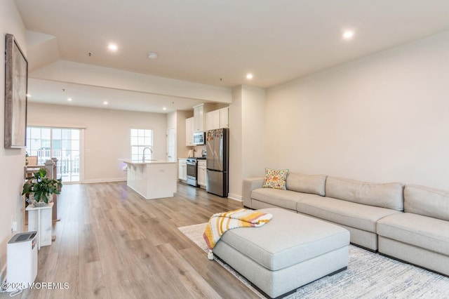 living room featuring recessed lighting, light wood-type flooring, and baseboards