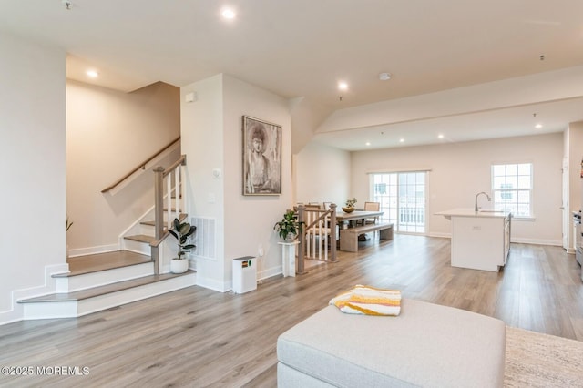 living area featuring visible vents, recessed lighting, light wood-type flooring, and baseboards