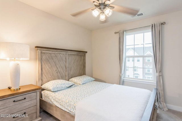 carpeted bedroom with visible vents, a ceiling fan, and baseboards