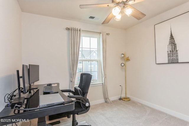 carpeted home office featuring visible vents, baseboards, and ceiling fan