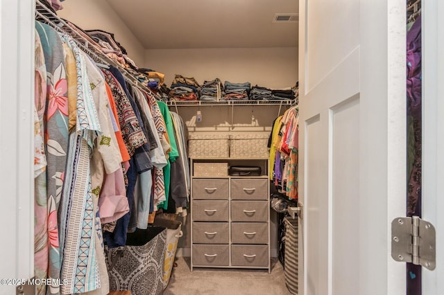 walk in closet with visible vents and light carpet