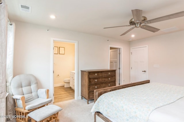 bedroom featuring visible vents, light carpet, ensuite bathroom, recessed lighting, and baseboards