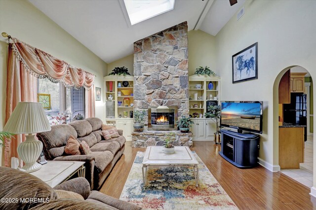 1500 First Ave, Toms River, NJ 08757 - living room with light wood-type flooring, visible vents, high vaulted ceiling, arched walkways, and a stone fireplace
