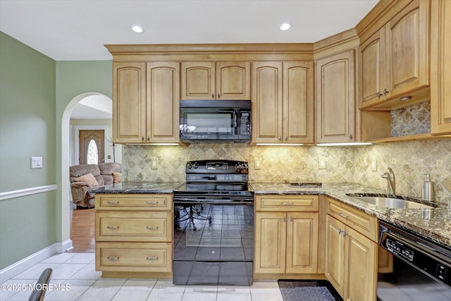 1500 First Ave, Toms River, NJ 08757 - kitchen with black appliances, a sink, dark stone countertops, arched walkways, and light tile patterned flooring